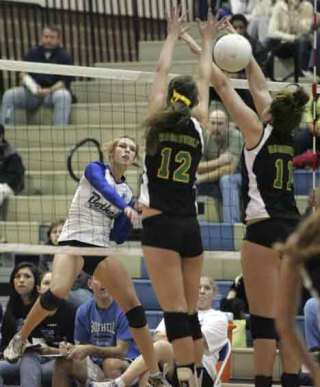 Bothell High's Blythe Cannon spikes the ball through two Roosevelt High defenders.