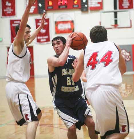 Cedar Park Christian senior Tommy McCullough drives to the basket while guarded by a pair of King's defenders during a 1A Tri-District game Wednesday night at King's in Shoreline. King's won