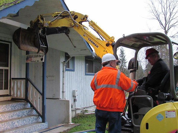 The American Legion National Commander takes a first swing at the building to be remodeled.