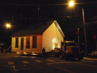 Movers swing the 106-year-old North Creek Schoolhouse through its first turn from 31st Avenue Southeast onto 228th Street last Saturday morning.