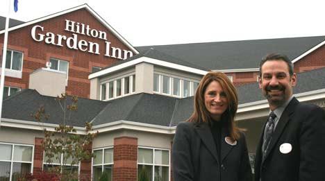 Director of Sales LeeAnne Brawner and General Manager Chip Peterson stand outside the new Bothell Hilton Garden Inn.