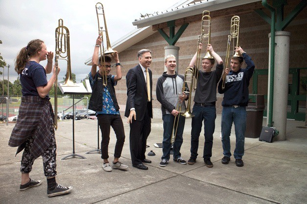 Dow Constantine stops to chat with some trombone students playing in a courtyard while visiting Inglemoor High School Thursday