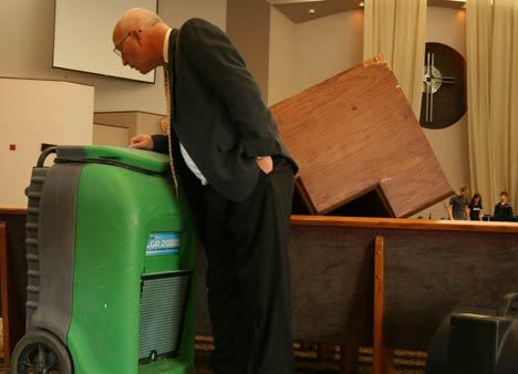 Cedar Park Assembly of God Pastor Joe Fuiten checks out one of the 20 dehumidifiers still working this morning to help clean the church's carpet