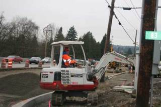 A construction worker moves concrete on State Route 522 in Kenmore.