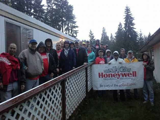 Honeywell employees gather for a photo after helping to renovate Bothell resident Mary Lou Judd's home.