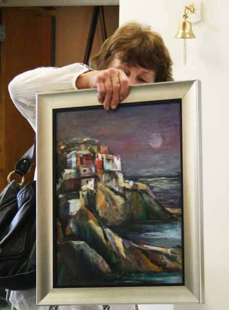Helga Jaques of Renton submits one of her paintings last Friday for the 12th annual Kenmore Art Show at Northlake Lutheran Church. The show runs Aug. 21-29.