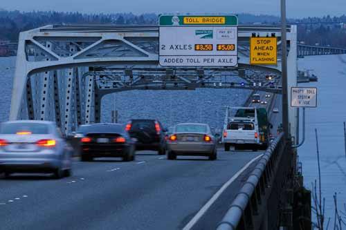 Traffic flows westbound across the State Route 520 floating bridge on the first day of active tolling in this view from Medina on Thursday morning.