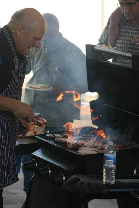 Kenmore Police Chief Clifford Sether grills up some burgers at the city's National Night Out gathering Tuesday at City Hall. The free event