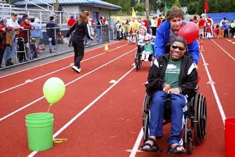 Whacky Wheelays participant Donny Bowe was one of the many who reached the finish line of his event with the help of volunteers such as David Huff.