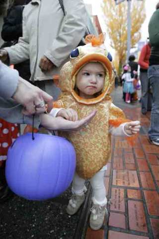 Ellie Tanferani tries some Halloween candy on Main Street in Bothell.