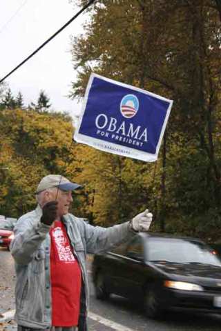 Tom Fitzpatrick of Kenmore waves his Obama for President sign yesterday near Kenmore's Arrowhead Elementary