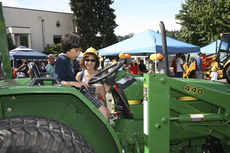 A young visitor to last year's RiverFest takes his turn atop a John Deere tractor
