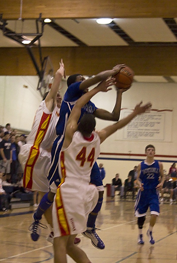 Bothell guard Perrion Callandret evades two Newport defenders