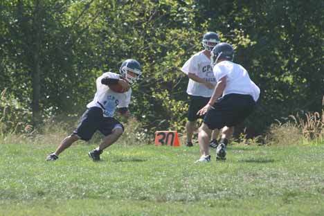 Ben Fuchs makes a move on two teammates Aug. 19 during the opening day of practice.