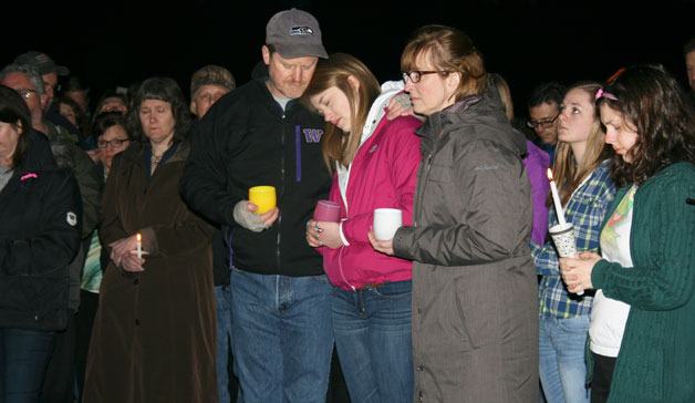 Sarah Paulson's parents Brad and Susan and sister Michelle huddle together during a candlelight vigil for Sarah Monday night.