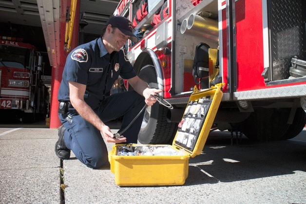 Firefigter Geoff Olson inspects EMS equipment outside of the Bothell Fire Station on Beardslee Road. Under the proposed RFA