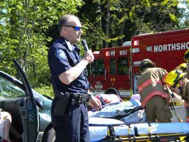 Kenmore Police Officer Mark Childers warns Inglemoor High students about the dangers of drinking and driving this morning at a staged accident as Viking senior Kate Hoffman plays a victim who has died on the scene of a prom-night crash involving a drunken driver. Story to come.