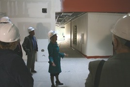 As other local and state officials look on in the semi-darkened building