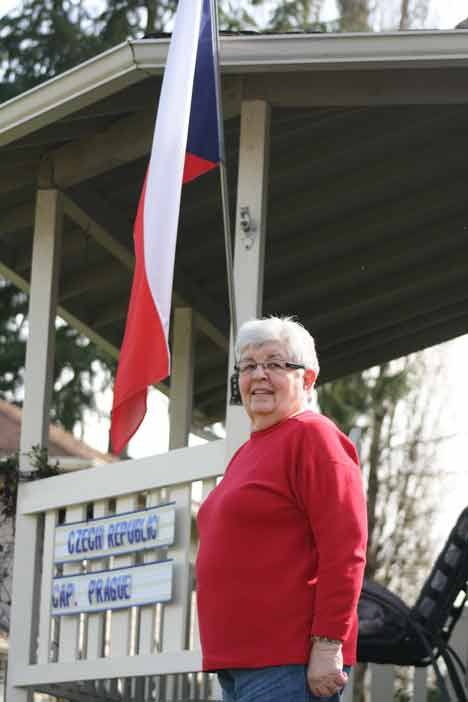 Lorraine Minshull stands proud with her Czech Republic flag in front of her Bothell home.