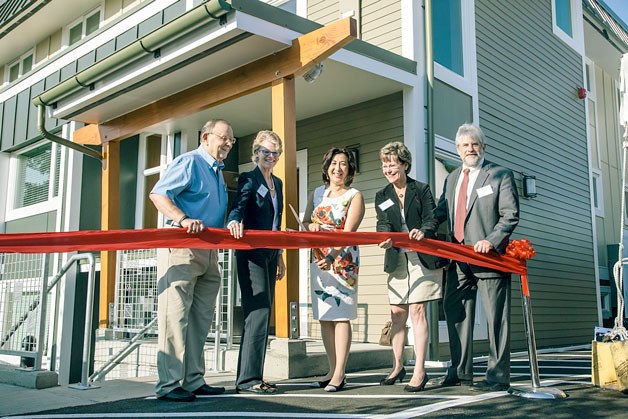 Hopelink CEO Lauren Thomas cuts the ribbon during the Aug. 18 grand reopening of Hopelink’s Kenmore Place shelter. With Thomas are