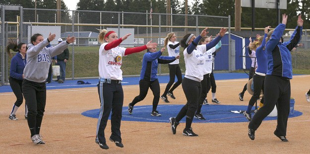 The Cougar softball team does stretching exercises in unison prior to a practice earlier this week at the Bothell High fastpitch field. Led by third-year coach Rob Luckey