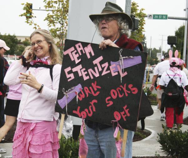 Rena and Roger Coon from Spokane cheer on the walkers today for the Susan G. Komen 3-Day for the Cure near Red Robin on Bothell-Everett Highway in Bothell. Their daughter and participant