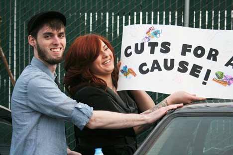 Kenmore’s Austin Edge checks out friend Tara Yaranon’s Cuts for a Cause sign she was set to display at Sunday night’s benefit concert for Austin’s dad