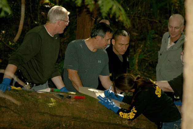 King County Sheriff's Office officials search an approximately 40 foot area in a densely wooded area on the Bastyr University campus on Friday afternoon