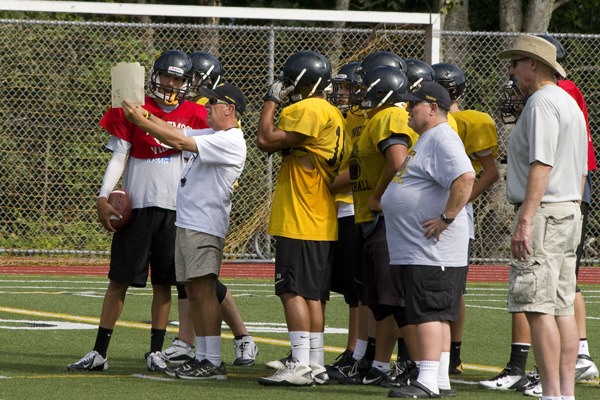 Inglemoor head football coach Frank Naish goes over a play with his offense during a practice at Inglemoor High. Naish serves as the team's offensive coordinator as well as the school's athletic director.