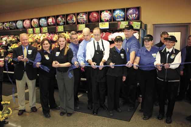 Staff members of the Canyon Park QFC hold a ribbon cutting last Sunday during the grand re-opening of the store.