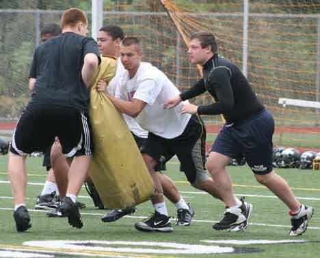 Inglemoor High football players get in some hits on a blocking pad this morning during the third day of practice.