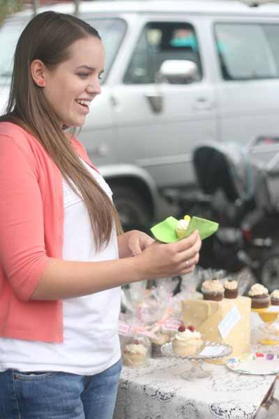Taylor Frazier sells cupcakes at the Bothell Farmers Market at Country Village on a recent Friday afternoon. All of her profits will go to the FEED Foundation.