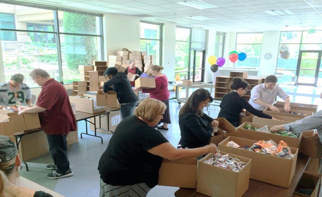 Employees at AT&T in Bothell prepare care packages for U.S. troops.