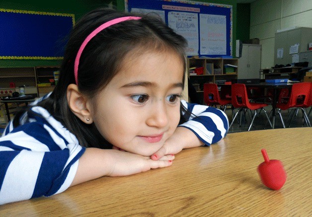 Hanukkah begins at sundown tonight for Jewish Northshore residents. Jewish Day School student Naomi Zang-Greene waits for the religious holiday while playing with a dreidel. She is from Bothell and is a Pre-Kindergarten student.