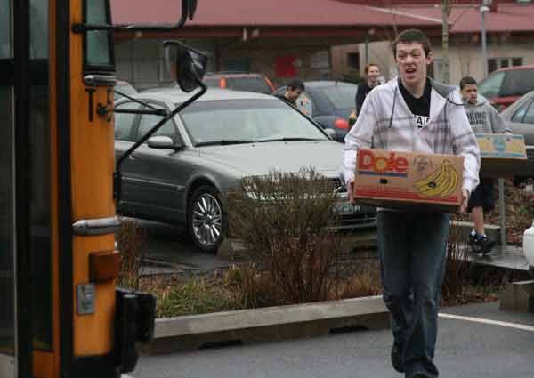 Kenmore Junior High Associated Student Body officer Patrick Olson leads the way in packing a school bus with food items that eventually went to the Concern for Neighbors food bank in Mountlake Terrace.