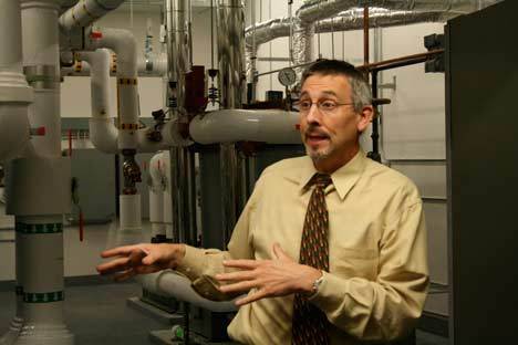 Student Mark French shows off the systems that help Cascadia Community College recycle rainwater last Thursday night during a tour.