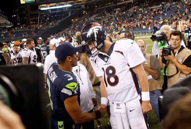 The Seahawks’ Russell Wilson and the Broncos’ Peyton Manning meet at midfield following the two teams’ preseason game in August.