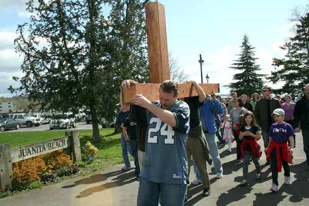 Nearly 200 members of the Eastside Foursquare Church walked a large wooden cross more than 2 miles from Juanita Beach Park in Kirkland to the Bothell church on Friday afternoon