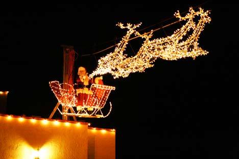 Santa prepares to 'fly in' on a wire atop one of the Country Village shops on Dec. 5.