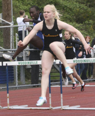 Inglemoor High’s Becca Berge outleaps Bothell High’s Charnele Odingo on her way to winning the 100-meter hurdles last Thursday at Woodinville High. PHOTOS BY ANDY NYSTROM