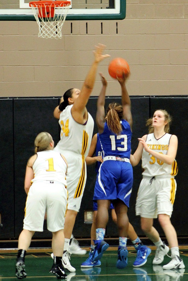 Inglemoor senior center Deja Strother blocks Cougar Kenyonna Jones as she drives to the basket.