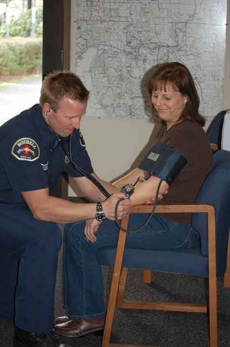 Bothell Firefighter Kirk Robinson administers a blood-pressure check at the city’s downtown firehouse.