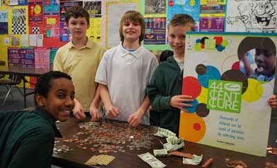 Heritage Christian Academy students count up some of the 44 Cent Cure donations. The sixth-graders are: (from left) Kaleb Tsegay