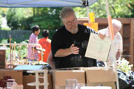 William Harker searches through boxes of used vinyl albums last Friday at the Northshore Senior Center rummage sale. The massive three-day sale featured thousands of items