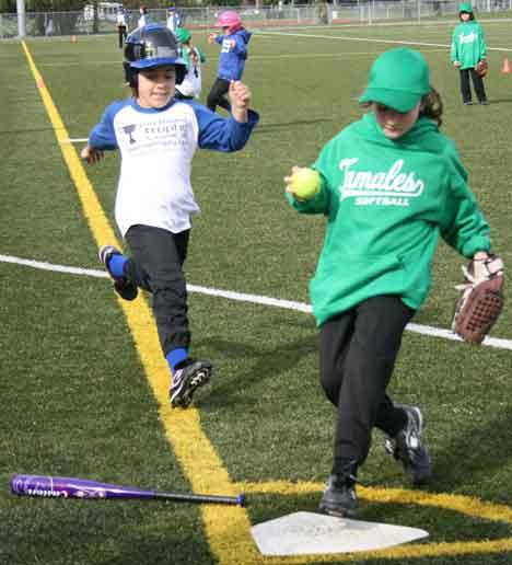 Tamale fielder Lyla Conrad forces Mustang runner Shaelyn Sharp out at home plate this morning during a Northshore Girls Slowpitch Softball Association jamboree game at North Creek Fields. The Mustangs won the first- and second-grader-division game.