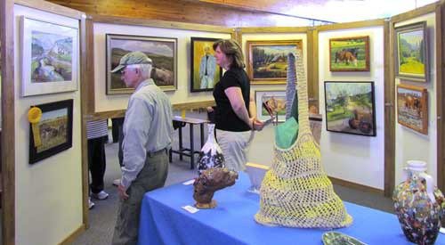 A pair of attendees check out items at the 13th annual Kenmore Art Show.