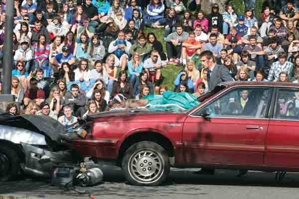 Austen Dahl checks on Abby Leonard during this morning's simulated DUI drill at Bothell High in front of the senior class.