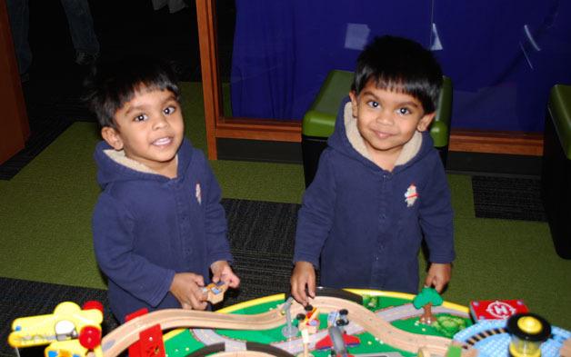 Twins Shreyan and Shrihan enjoy Kindering Bothell’s train room during the grand opening event.