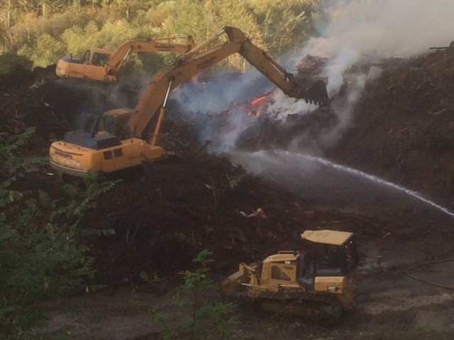 Firefighters work to extinguish the mulch blaze.