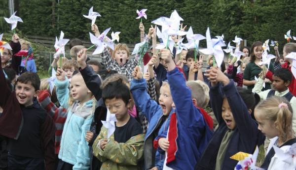 Evergreen Academy students in Bothell raise their pinwheels before placing them in their natural organic garden this morning on the United Nation's International Day of Peace.